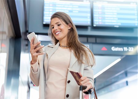 revisando - Businesswoman with passport using cell phone in airport Foto de stock - Sin royalties Premium, Código: 6113-08784153