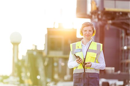 simsearch:6113-08784226,k - Portrait confident female air traffic controller with walkie-talkie on airport tarmac Foto de stock - Sin royalties Premium, Código: 6113-08784176