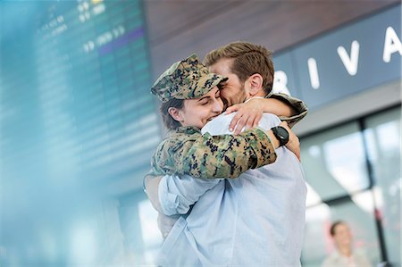 Husband greeting and hugging soldier wife at airport Stock Photo - Premium Royalty-Free, Code: 6113-08784182