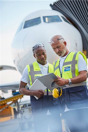 Air traffic controllers with clipboard below airplane on airport tarmac Stock Photo - Premium Royalty-Free, Code: 6113-08784249
