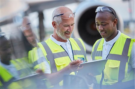 plane front - Air traffic control ground crew workers talking using digital tablet on airport tarmac Stock Photo - Premium Royalty-Free, Code: 6113-08784286