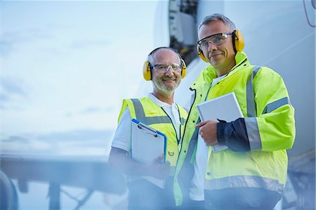 Portrait confident air traffic control ground crew workers with digital tablet near airplane on tarmac Photographie de stock - Premium Libres de Droits, Code: 6113-08784289