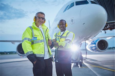 pista d'atterraggio - Portrait confident air traffic control ground crew workers near airplane on airport tarmac Fotografie stock - Premium Royalty-Free, Codice: 6113-08784297