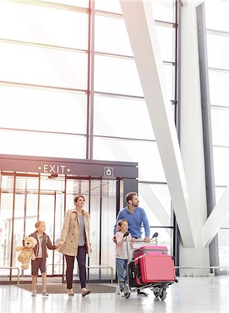 family and vacation and airport - Family arriving pushing luggage cart in airport concourse Foto de stock - Sin royalties Premium, Código: 6113-08784204