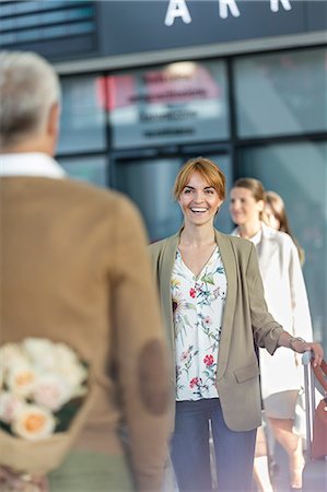 Husband surprising wife with flowers at airport Stock Photo - Premium Royalty-Free, Code: 6113-08784230