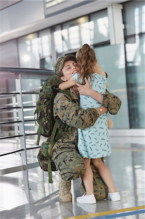 returns - Daughter greeting hugging soldier mother at airport Stock Photo - Premium Royalty-Free, Code: 6113-08784317