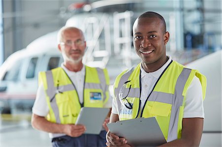 Portrait smiling air traffic control ground crew worker with clipboard Stock Photo - Premium Royalty-Free, Code: 6113-08784314