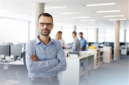 simsearch:6113-09058718,k - Portrait serious businessman with arms crossed in office Foto de stock - Royalty Free Premium, Número: 6113-08784476