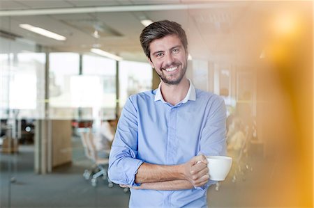 Portrait confident businessman drinking coffee in office Stock Photo - Premium Royalty-Free, Code: 6113-08784488