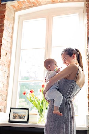 simsearch:6113-07731336,k - Mother holding baby daughter at window Photographie de stock - Premium Libres de Droits, Code: 6113-08784404