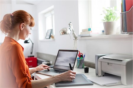 drawing woman - Designer using graphics tablet at laptop in office Stock Photo - Premium Royalty-Free, Code: 6113-08784414