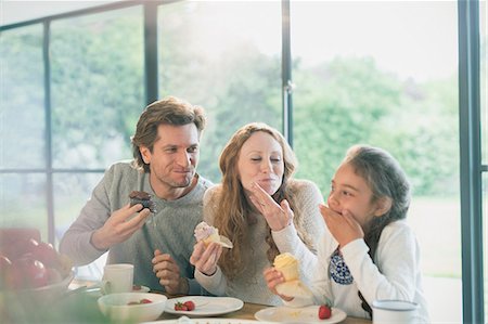 people eating desserts - Family eating cupcakes at table Stock Photo - Premium Royalty-Free, Code: 6113-08722048