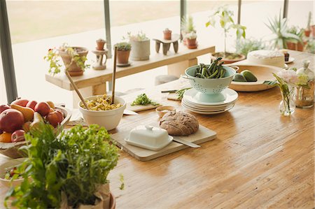 Bread, butter, fruit, pasta,asparagus and fresh herbs on dining room table Stock Photo - Premium Royalty-Free, Code: 6113-08722081