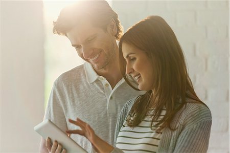 Smiling couple using digital tablet Stock Photo - Premium Royalty-Free, Code: 6113-08722090