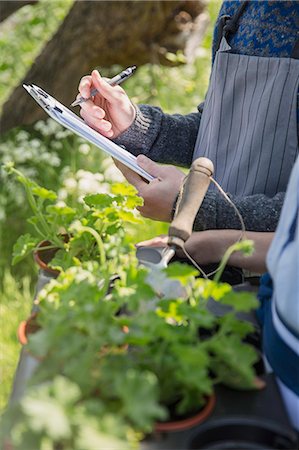 simsearch:694-03692195,k - Close up plant nursery workers with clipboard and potted herbs Stock Photo - Premium Royalty-Free, Code: 6113-08722173