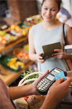 shopping cashier - Woman watching grocery store clerk using credit card machine Stock Photo - Premium Royalty-Free, Code: 6113-08722170
