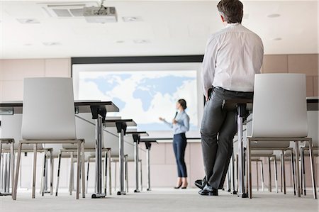 simsearch:649-07520125,k - Businessman watching businesswoman leading presentation at projection screen in conference room Foto de stock - Sin royalties Premium, Código: 6113-08722123