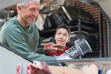 simsearch:6113-08722257,k - Smiling father and son fixing car engine in auto repair shop Photographie de stock - Premium Libres de Droits, Code: 6113-08722252