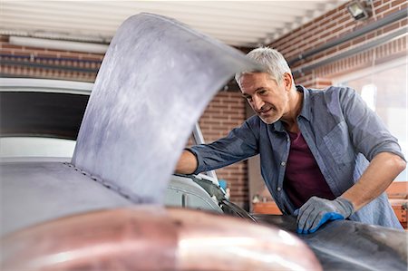 simsearch:6113-08722257,k - Mechanic looking under automobile hood in auto repair shop Photographie de stock - Premium Libres de Droits, Code: 6113-08722258