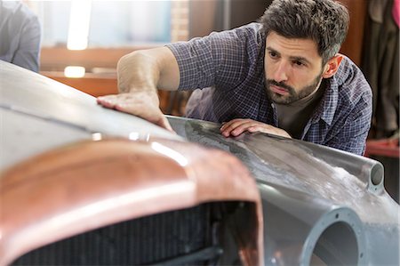 simsearch:6113-07565134,k - Focused mechanic examining classic car panel in auto repair shop Stock Photo - Premium Royalty-Free, Code: 6113-08722268