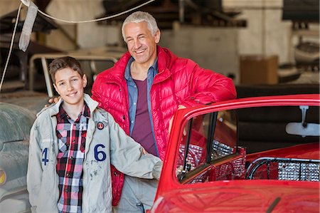 Portrait smiling father and son next to classic car in auto repair shop Stock Photo - Premium Royalty-Free, Code: 6113-08722269