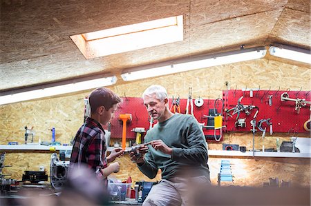 family occupation - Father explaining tool to son in auto repair shop Stock Photo - Premium Royalty-Free, Code: 6113-08722270