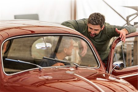 Mechanics talking at classic car in auto repair shop Foto de stock - Sin royalties Premium, Código: 6113-08722277