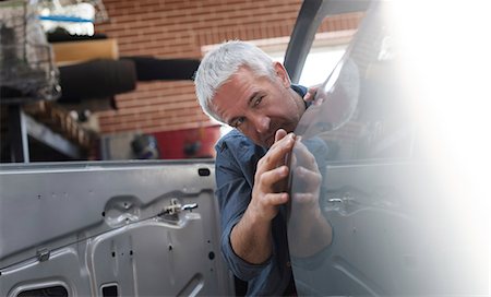simsearch:614-09057420,k - Mechanic examining car panel in auto repair shop Stock Photo - Premium Royalty-Free, Code: 6113-08722283