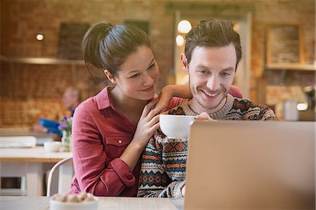 simsearch:6113-08927652,k - Smiling couple drinking coffee using laptop at cafe Foto de stock - Sin royalties Premium, Código: 6113-08722201