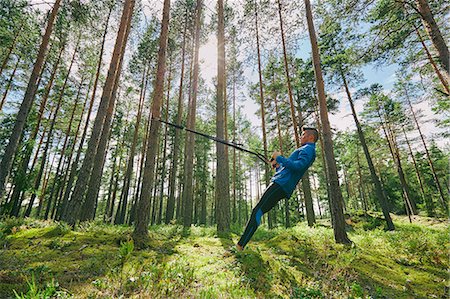 simsearch:6113-08943763,k - Runner stretching with resistance band on tree in woods Photographie de stock - Premium Libres de Droits, Code: 6113-08722211