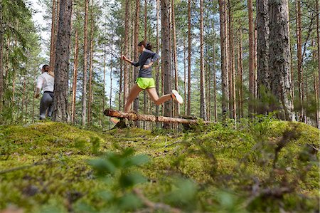 simsearch:6122-07703835,k - Runner jumping over fallen log in woods Stock Photo - Premium Royalty-Free, Code: 6113-08722215