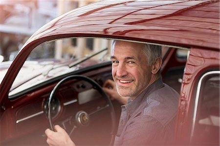 posing with car - Portrait smiling mechanic inside classic car Stock Photo - Premium Royalty-Free, Code: 6113-08722223