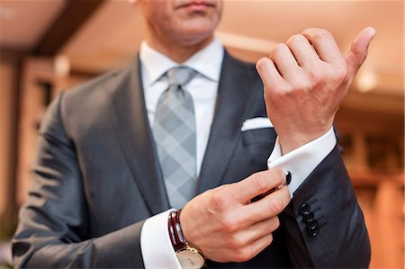 Close up well-dressed businessman adjusting cufflinks Foto de stock - Sin royalties Premium, Código: 6113-08722365