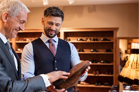 simsearch:6113-08722332,k - Worker showing dress shoes to businessman in menswear shop Stock Photo - Premium Royalty-Free, Code: 6113-08722366