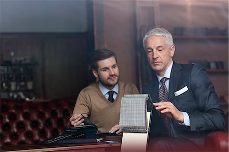 Tailor and businessman browsing fabric in menswear shop Stock Photo - Premium Royalty-Free, Code: 6113-08722320