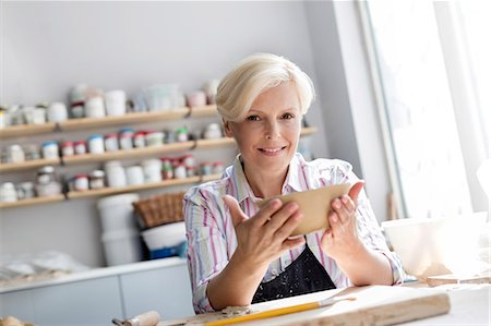 Portrait smiling mature woman holding bowl in pottery studio Stock Photo - Premium Royalty-Free, Code: 6113-08722400