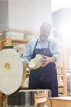 Man examining pottery at kiln in studio Stock Photo - Premium Royalty-Free, Code: 6113-08722438