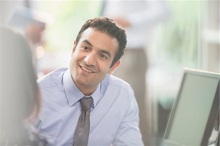 Attentive, smiling businessman listening to colleague in meeting Stock Photo - Premium Royalty-Free, Code: 6113-08882451