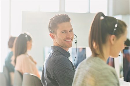 simsearch:6113-07243069,k - Portrait smiling male telemarketer wearing headset at computer in sunny office Stock Photo - Premium Royalty-Free, Code: 6113-08882541