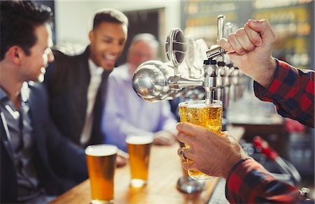 Bartender pouring beer from tap behind bar Stock Photo - Premium Royalty-Free, Code: 6113-08882561
