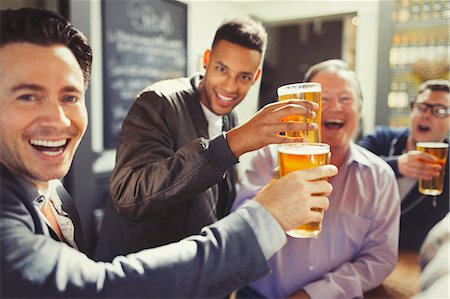 Enthusiastic men friends toasting beer glasses at bar Stock Photo - Premium Royalty-Free, Code: 6113-08882569