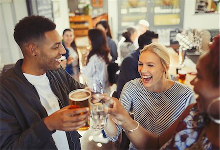 people laughing in pub - Laughing friends toasting beer and wine glasses at bar Stock Photo - Premium Royalty-Free, Code: 6113-08882582