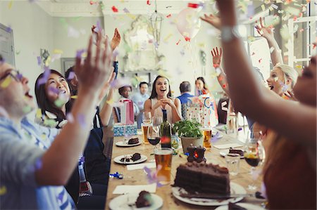 people eating desserts - Friends celebrating birthday throwing confetti overhead at restaurant table Stock Photo - Premium Royalty-Free, Code: 6113-08882672