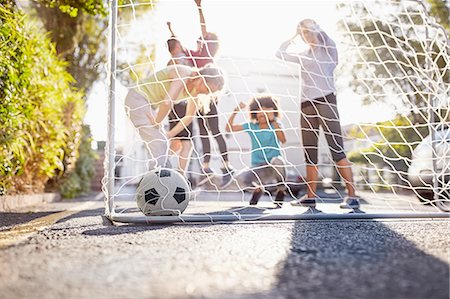 simsearch:6113-08882733,k - Friends playing soccer on sunny urban summer street Stock Photo - Premium Royalty-Free, Code: 6113-08882746