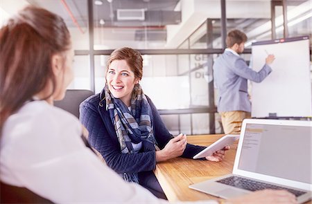 simsearch:6113-07790910,k - Smiling businesswomen with digital tablet and laptop talking in conference room meeting Stock Photo - Premium Royalty-Free, Code: 6113-08882755