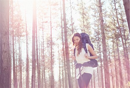 Young woman with backpack hiking in sunny woods Photographie de stock - Premium Libres de Droits, Code: 6113-08882769