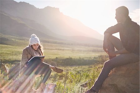 Young couple hiking, resting and writing in sunny remote field Photographie de stock - Premium Libres de Droits, Code: 6113-08882790