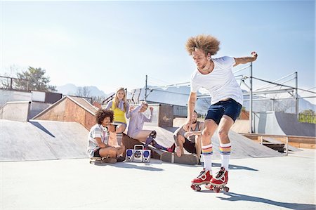 simsearch:6113-08882727,k - Friends watching man roller skating at sunny skate park Stock Photo - Premium Royalty-Free, Code: 6113-08882708