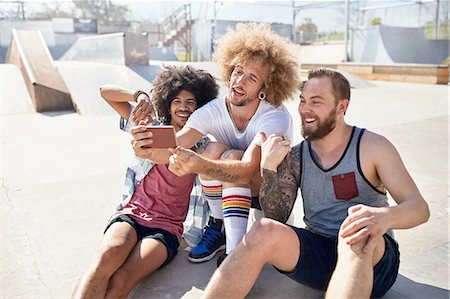 simsearch:6113-08698226,k - Male friends with camera phone taking selfie at sunny skate park Stock Photo - Premium Royalty-Free, Code: 6113-08882730
