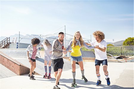 Friends roller skating at sunny skate park Stock Photo - Premium Royalty-Free, Code: 6113-08882732